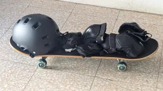 Monopatín con protecciones y casco