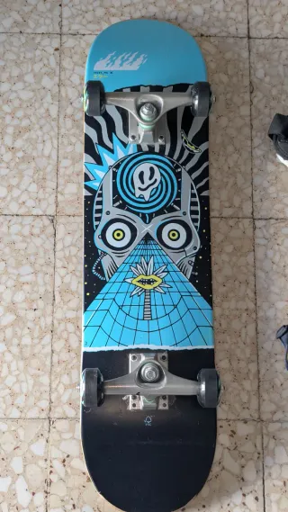 Monopatín con protecciones y casco