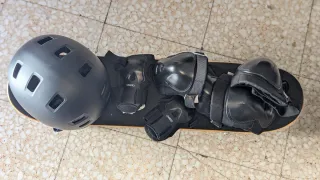 Monopatín con protecciones y casco