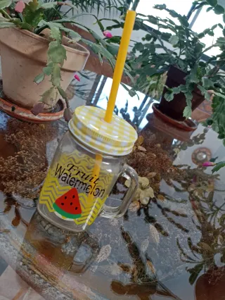 Vaso de vidrio con pajita y tapa