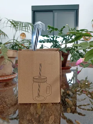 Vaso de cristal con tapa negra y pajita