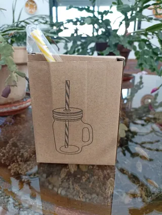 Vaso de cristal con tapa dorada y pajita