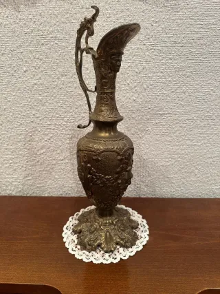 Conjunto de candelabros, reloj y jarra de bronce