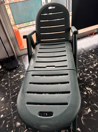 Tumbona de plástico verde plegable.