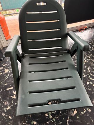 Tumbona de plástico verde plegable.