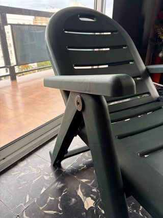 Tumbona de plástico verde plegable.