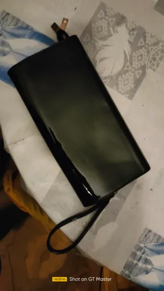 Cartera negra de charol con detalle dorado