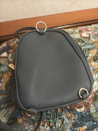 Zainetto grigio con V dorata e nappe