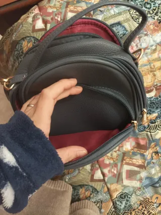 Zainetto grigio con V dorata e nappe