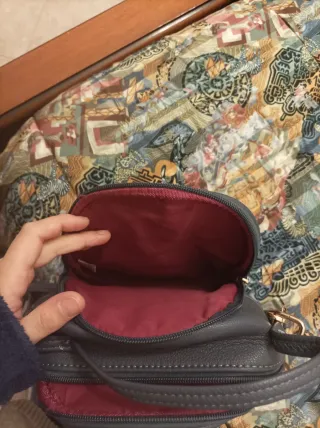 Zainetto grigio con V dorata e nappe