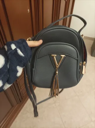 Zainetto grigio con V dorata e nappe