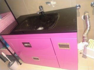 Mueble de baño rosa con lavabo negro