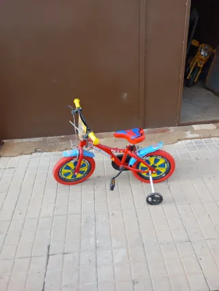 Bicicleta infantil roja con ruedines