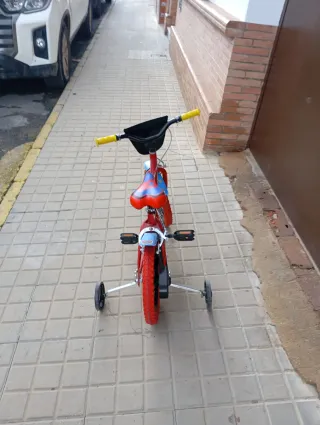 Bicicleta infantil roja con ruedines