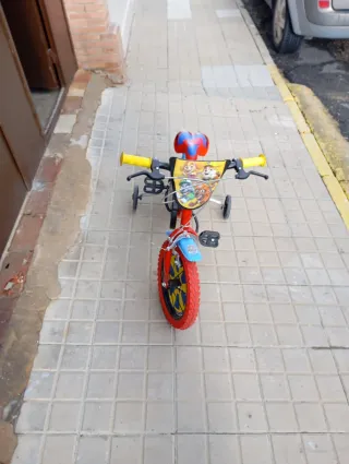 Bicicleta infantil roja con ruedines