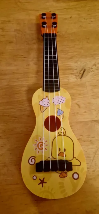 Ukelele de juguete amarillo con dibujos