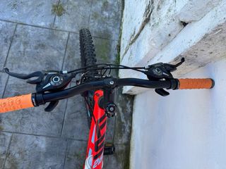 Bicicleta de montaña roja anaranjada.