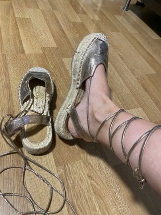 Sandalias doradas atadas al tobillo