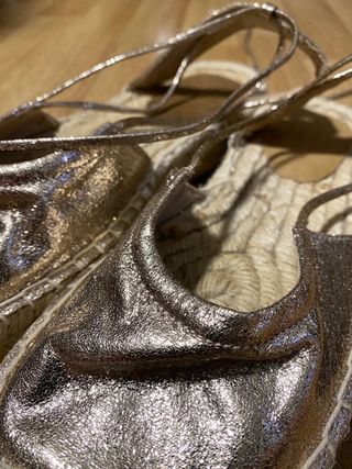 Sandalias doradas atadas al tobillo