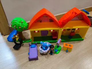 Casa de blue de juguete con tobogán y árbol
