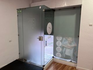 Puerta de cristal con cerradura y mamparas