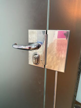 Puerta de cristal con cerradura y mamparas