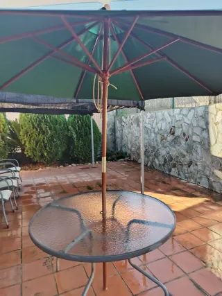 Parasol de madera y tela para mesa de terraza.