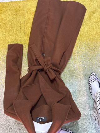 Gabardina marrón claro con cinturón.