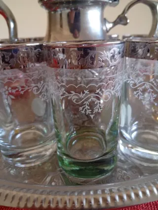 Tetera y vasos de metal y cristal