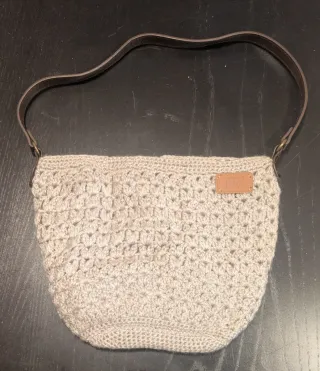 Bolso de crochet beige con asa de cuero