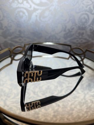 Gafas de sol negras con detalle dorado