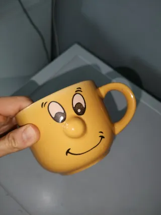Tazza gialla con faccia sorridente