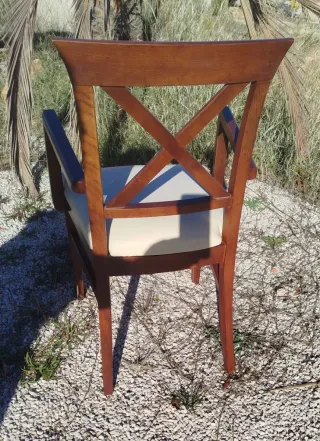 Silla de madera con brazos y asiento beige