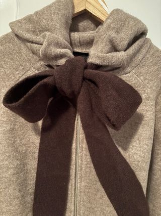 Chaqueta de punto beige con lazo marrón