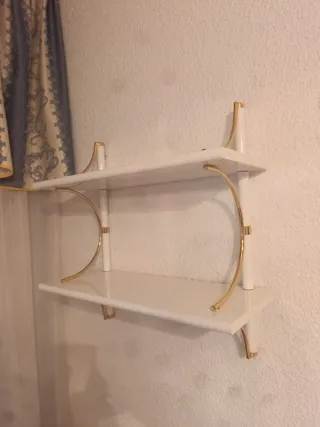 Estantería de pared blanca y dorada