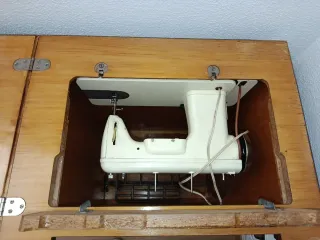 Máquina de coser Singer beige con mueble.