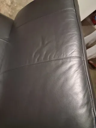 Divano in pelle nero con cuscino viola