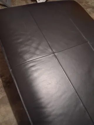 Divano in pelle nero con cuscino viola