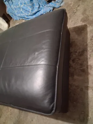 Divano in pelle nero con cuscino viola