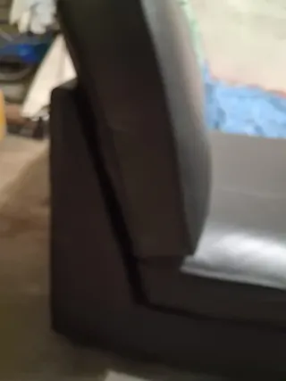 Divano in pelle nero con cuscino viola