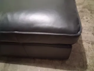 Divano in pelle nero con cuscino viola