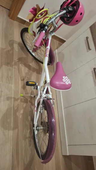 Bicicleta infantil rosa con casco