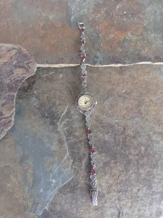 Reloj de plata con piedras rojas