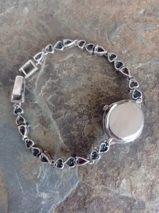 Reloj de plata con piedras rojas