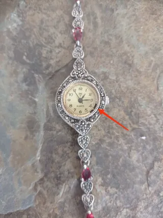 Reloj de plata con piedras rojas