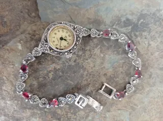Reloj de plata con piedras rojas