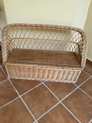 Sillón de mimbre con respaldo y espacio interno.