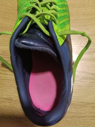 Botas de fútbol Adidas verdes con azul.