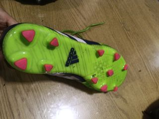 Botas de fútbol Adidas verdes con azul.