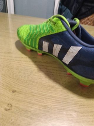 Botas de fútbol Adidas verdes con azul.